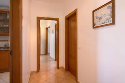 a hallway with two doors and a painting on the wall at Quarteira Beach iii in Quarteira