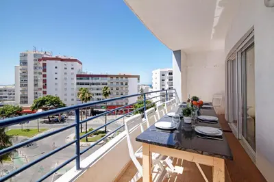 a balcony with a table and a view of the city at Quarteira Beach ii in Quarteira