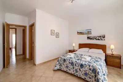 a bedroom with a bed with two towels on it at Quarteira Beach ii in Quarteira