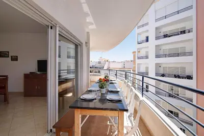 a dining table on the balcony of a building at Quarteira Beach ii in Quarteira