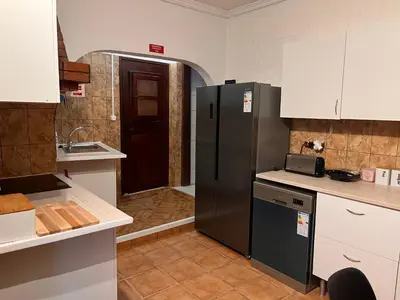 a kitchen with a black refrigerator and a sink at Casa Amarela in Loulé