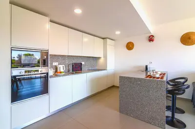 a kitchen with white cabinets and a counter top at Marvell Design with heated pool&Playground in Albufeira