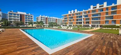 a swimming pool in front of some apartment buildings at Marvell Design with heated pool&Playground in Albufeira