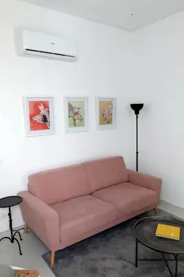 a living room with a pink couch and some pictures at Arty Casa in Faro