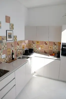 a white kitchen with white cabinets and a sink at Arty Casa in Faro