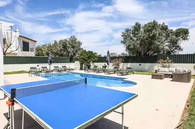 a ping pong table in a backyard with a pool at Villa O Sonho do Algarve - Private Swimming Pool - BY BEDZY in Albufeira