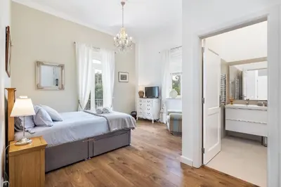 a bedroom with a large bed and a bathroom at Villa Isabella by OCvillas in Paderne