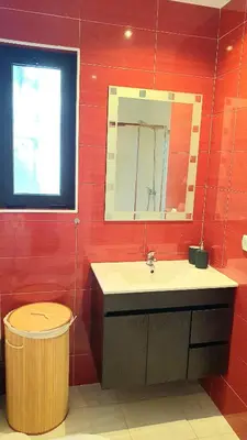 a bathroom with a sink and a mirror and a trash can at Apartment São Rafael 63 - Beach - Pool - Free wi-fi - Air Con in Albufeira