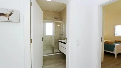 a bathroom with white walls and a shower and a sink at Vila Renascer-CleverDetails, few minutes from the center, quiet area in Vilamoura