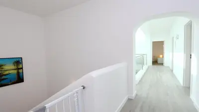 a white staircase in a house with a painting on the wall at Vila Renascer-CleverDetails, few minutes from the center, quiet area in Vilamoura