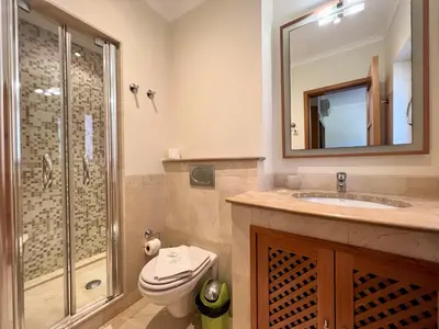 a bathroom with a toilet and a sink and a shower at Vilamoura Victoria Gardens With Pool by Homing in Vilamoura