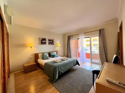 a bedroom with a bed and a large window at Vilamoura Victoria Gardens With Pool by Homing in Vilamoura
