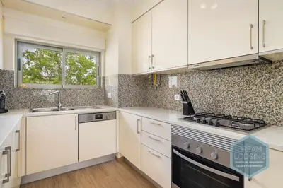 a kitchen with white cabinets and a stove and a window at Jardins da Marina - Dream Lodging in Albufeira