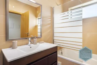 a bathroom with a sink and a mirror and a tub at Jardins da Marina - Dream Lodging in Albufeira
