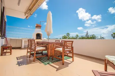 a patio with a table and chairs on a balcony at Apartment close to golf, beaches, Quinta Lago, Vale Lobo, Quarteira and Vilamoura in Quinta do Lago