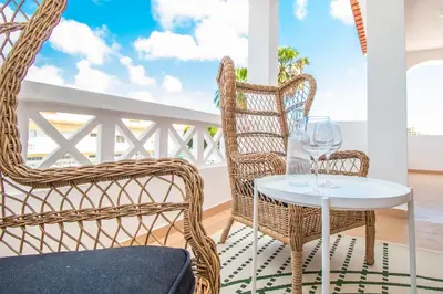 a patio with two chairs and a table with wine glasses at Apartment close to golf, beaches, Quinta Lago, Vale Lobo, Quarteira and Vilamoura in Quinta do Lago