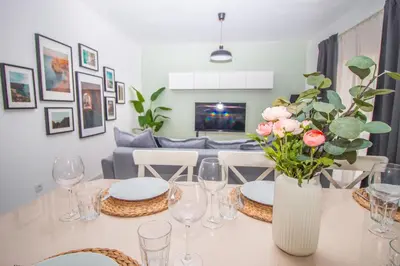 a dining room table with a vase of flowers on it at Apartment close to golf, beaches, Quinta Lago, Vale Lobo, Quarteira and Vilamoura in Quinta do Lago