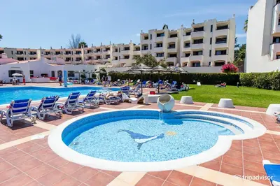 a swimming pool with a dolphin in the middle of a resort at A CASA da PRAIA ALBUFEIRA PORTUGAL in Albufeira