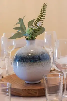 a vase with a plant in it on a table with glasses at Downtown & Beach in Albufeira