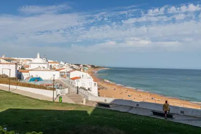 a person walking on a beach near the ocean at Downtown & Beach in Albufeira