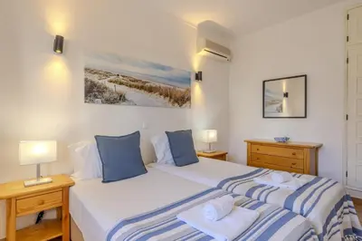 a bedroom with a bed with blue and white sheets at #014 Mar & Praia Albufeira by Home Holidays in Albufeira