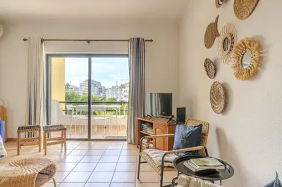 a living room with a television and a balcony at #014 Mar & Praia Albufeira by Home Holidays in Albufeira