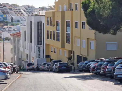 a parking lot with cars parked next to a building at Apartamento Solaris T1 - Férias Albufeira in Albufeira