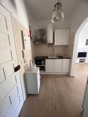 a kitchen with white cabinets and a white door at Apartamento Solaris T1 - Férias Albufeira in Albufeira