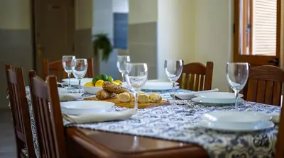 a dining table with wine glasses and food on it at Villa Girassol - By Dalma Portuguesa in Albufeira