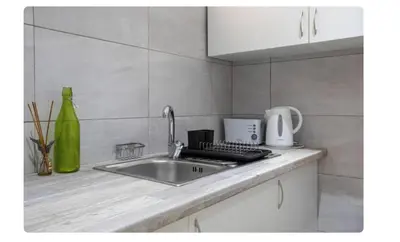 a kitchen counter top with a sink and a mixer at BeGuest Casetta Cleo in Páteo
