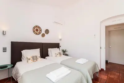 two beds in a room with white walls at Casas Barulho - Villa Jacaranda A8 in Albufeira