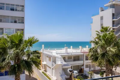 a view of the ocean from the balcony of a building at Stylish Modern Beachside Apartment with Pool & Seaview in Quarteira