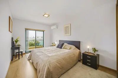 a bedroom with a bed and a desk and a window at Penthouse Escape with Large Terrace, Pool & Garden in Quarteira