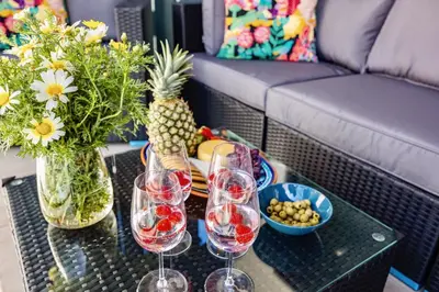 a coffee table with wine glasses and a couch at Bright Modern Beachside Apartment with Pool & Seaview in Quarteira
