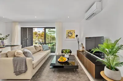 a living room with a couch and a table at 2-Bedroom Beachside Apartment with Pool & Parking in Quarteira