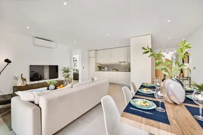 a living room with a couch and a table with food on it at 2-Bedroom Beachside Apartment with Pool & Parking in Quarteira