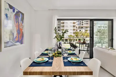 a dining room with a table with plates of food at 2-Bedroom Beachside Apartment with Pool & Parking in Quarteira