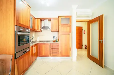 a kitchen with wooden cabinets and an open door at Albufeira - Cerro Mar Star - Cozy and Relaxing T1 in Albufeira