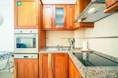 a kitchen with wooden cabinets and a sink at Albufeira - Cerro Mar Star - Cozy and Relaxing T1 in Albufeira