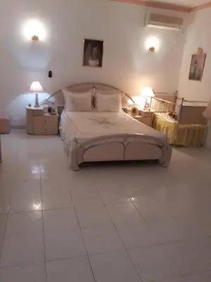a bedroom with a large bed with two tables and two lamps at Algarve Paraíso Casa Lagos e Relvas in Estói