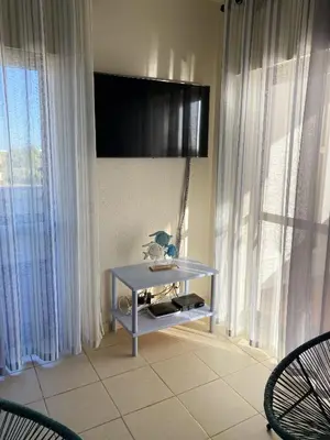 a bedroom with two beds with towels and a television at Charming Vilamoura Apartment with Shared Pool in Vilamoura