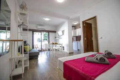 a bedroom with a bed and a living room with a table at Vilamoura Golf Studio With Pool by Homing in Vilamoura