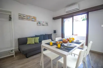 a living room with a table and a couch at Vilamoura Golf Studio With Pool by Homing in Vilamoura