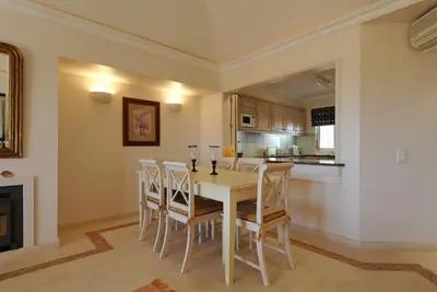 a kitchen and dining room with a table and chairs at Tulio 2 Bedroom Luxury Apartment located in Encosta Do Lago in Quinta do Lago