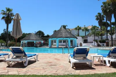 a group of lounge chairs and a swimming pool at Tulio 2 Bedroom Luxury Apartment located in Encosta Do Lago in Quinta do Lago