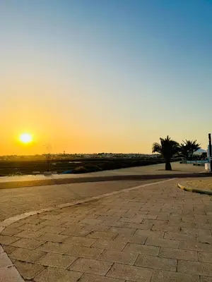 an empty parking lot with the sunset in the background at Fisherman´s Cave in Faro