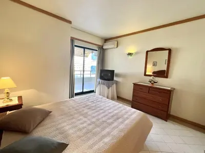 a bedroom with a bed and a mirror and a television at Talia XII - Near the beach by HD PROPERTIES in Vilamoura