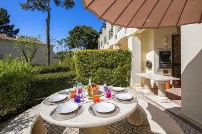 a table with plates and drinks on a patio at Sera - Luxury 3 bedroom apartment with pool, golf,beach in Ludo