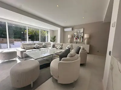 a living room with a couch and a table and chairs at Sunshine - PINHEIROS ALTOS in Quinta do Lago