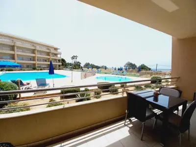 a balcony with a table and a view of a pool at Barracuda ByTheSea in Albufeira